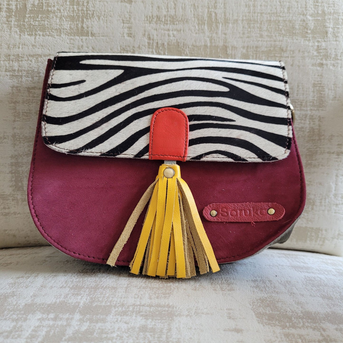 Sac Lena Soruka en Croûte de Cuir : Imprimé animalier, Pompon Coloré & Multi-Soufflets